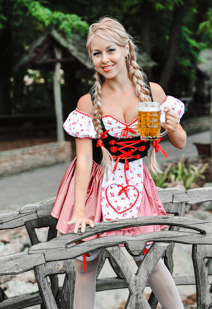 Mooie blanke vrouw met bier in jurk. Oktoberfest Festival. - Foto, afbeelding