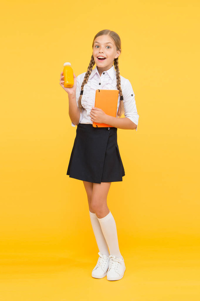 lunch time. small girl child with book. reading and writing. happy girl study hard with notebook. literature lesson. back to school. Pupil drink juice at library. healthy food. diary and dairy - Фото, изображение