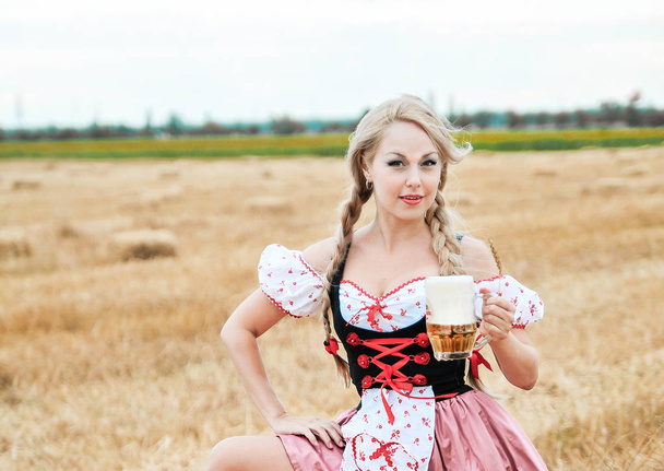 schöne kaukasische Frau im Kleid mit Bier. Oktoberfest. - Foto, Bild