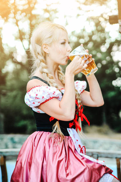 Beautiful caucasian wwoman in dress with beer. Octoberfest festival. - 写真・画像