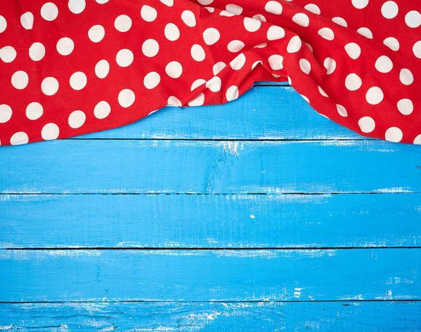 červený textilní ručník s bílými kruhy na modrém dřevěném pozadí - Fotografie, Obrázek