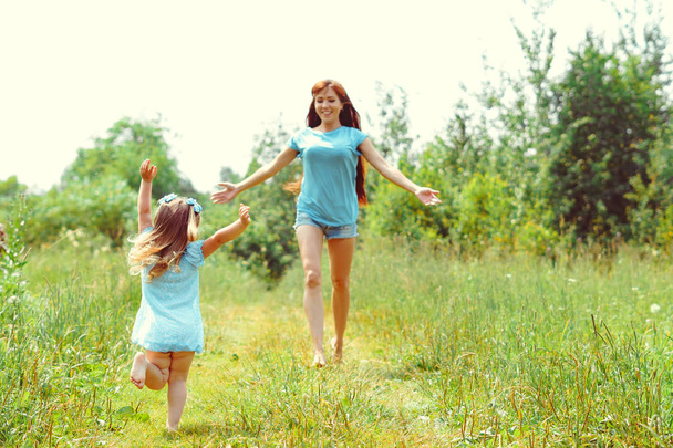 daughter runs towards her mother on the grass - Photo, Image