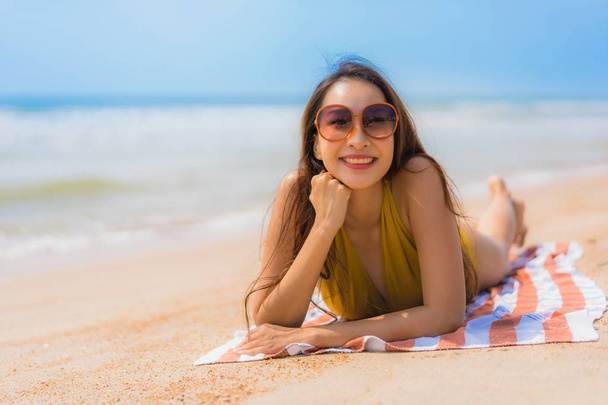 Muotokuva kaunis nuori aasialainen nainen hymyillä onnellinen rannalla
 - Valokuva, kuva