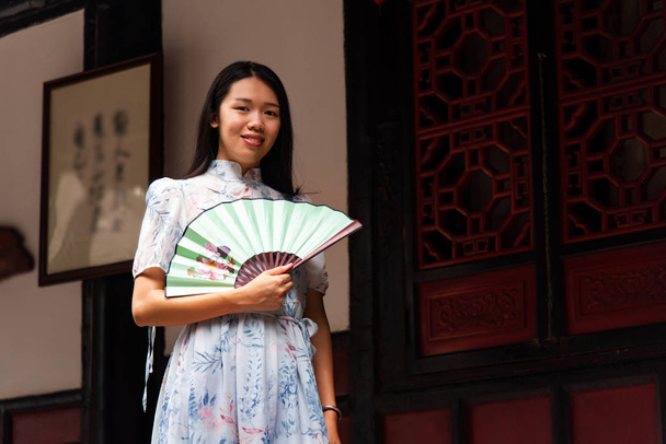 asiatische Frau in einem Tempel mit einem Handfächer - Foto, Bild