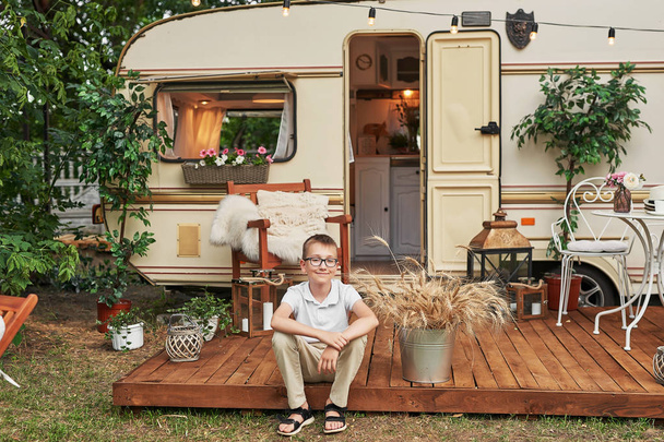 child boy near a caravan in the summer at sunset - Photo, Image