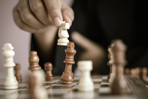 Крупним планом застрелена рука ділової жінки, яка грає в шахову дошку, щоб
  - Фото, зображення