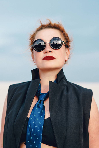 loco divertido grunge punk pelirroja mujer con rastas en ropa de oficina y gafas de sol en el desierto
  - Foto, Imagen