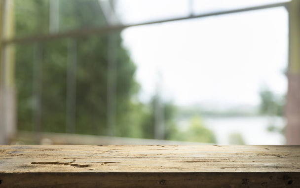 Vuoto del tavolo in legno su sfocatura della tenda con finestra vista verde da sfondo giardino albero. Per esposizione del prodotto di montaggio o layout visivo chiave di design
 - Foto, immagini