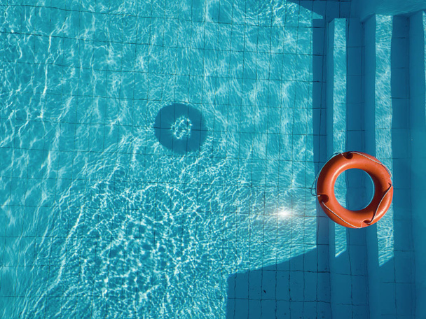 Oranssi pelastusrengas uima-altaassa kesällä
 - Valokuva, kuva