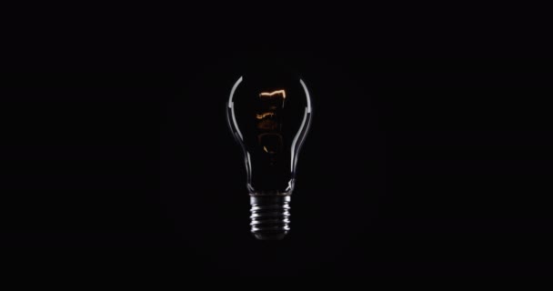 Tungsten light bulb lamp over black background - Footage, Video