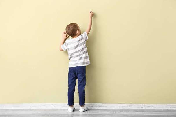 Little boy drawing on color wall - Photo, image