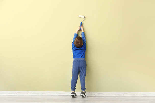 Милий маленький хлопчик малює стіну в кімнаті
 - Фото, зображення