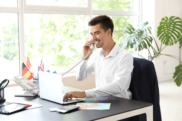 Male travel agent working in office - Photo, Image