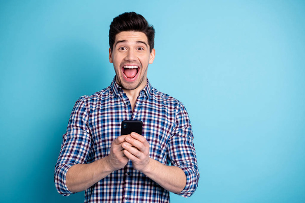 Closeup photo portrait of shocked wow omg amazed wondered astonished cool with opened mouth user holding telephone in hands isolated pastel background - Foto, Imagem