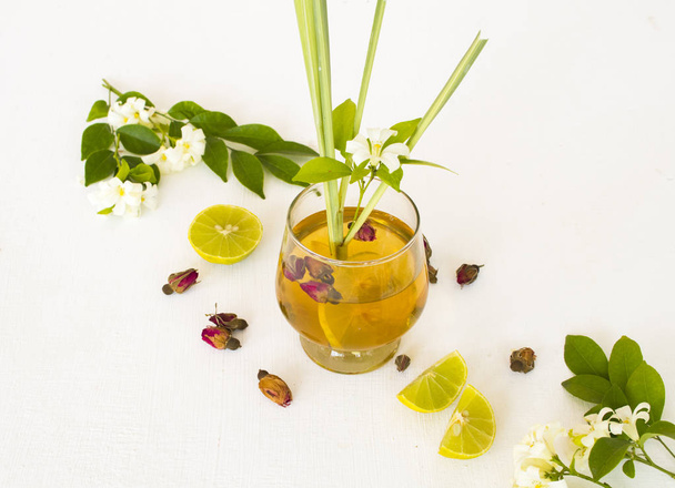 natural herbal healthy drink for cough sore mix rose tea ,lemon arrangement flat lay style with flower jasmine ,lemon slice ,dried rose on background white - Fotó, kép