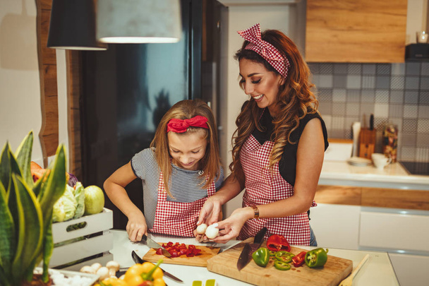 Mutlu anne ve kızı ev mutfak, sağlıklı yemek yapımında eğleniyor - Fotoğraf, Görsel