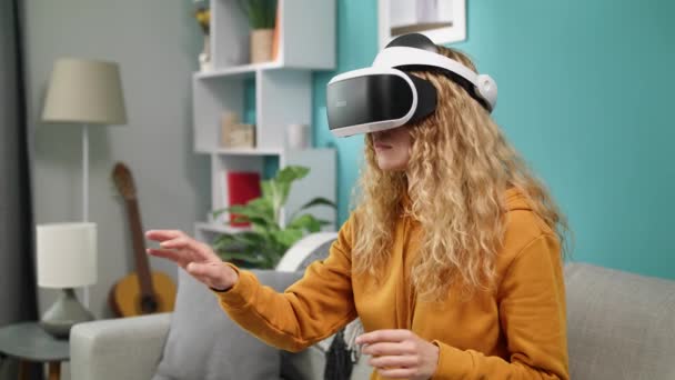 Woman in the VR glasses having VR headset in the room at home - Felvétel, videó