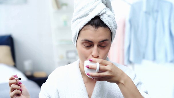 bornozlu kadın göz farı uygulayarak ve kahve içerek - Video, Çekim
