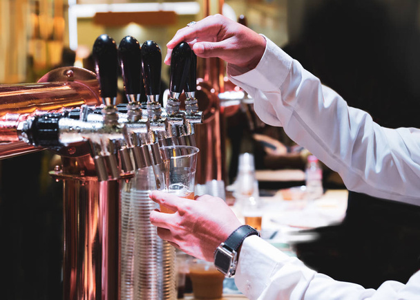 Бармен наливает разливное пиво в бар, бармен за пивной кран
 - Фото, изображение