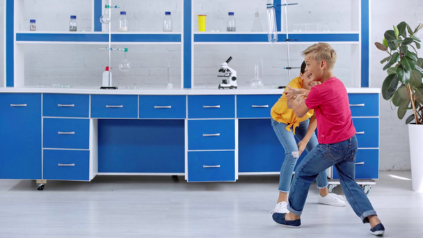 szczęśliwe dzieci w dżinsach grających w laboratorium  - Materiał filmowy, wideo