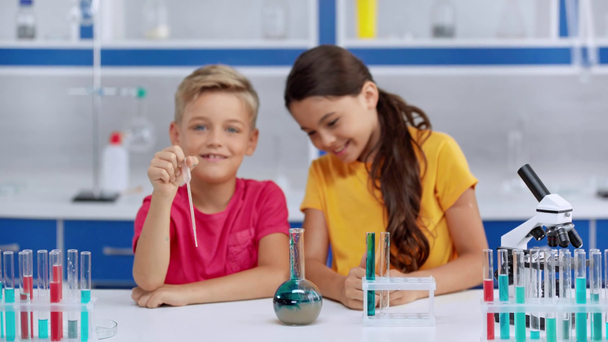 enfoque selectivo de los niños que agregan líquido azul en el agua
  - Imágenes, Vídeo