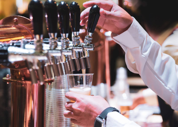 Barman wylewanie piwo projekt w barze, ręka baru na piwo kranu - Zdjęcie, obraz