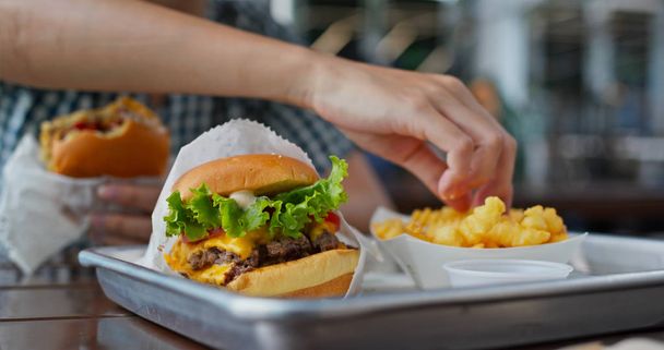 Donna mangiare hamburger nel ristorante fast food
 - Foto, immagini