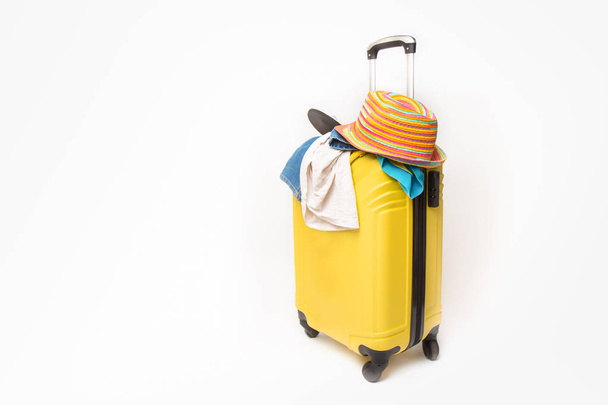 yellow suitcase with clothes of ttourist on a white background. concept quick fees late on the plane - Φωτογραφία, εικόνα
