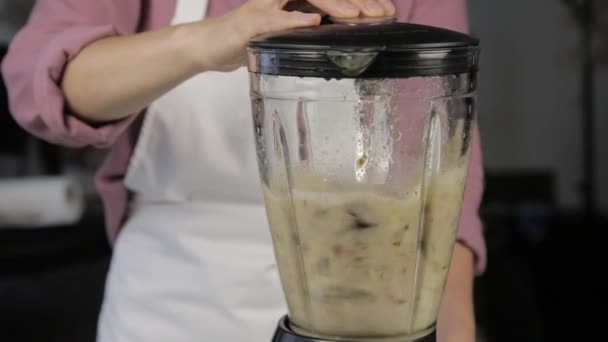 woman cooking at home, banana chocolate shake. mixing ingredients in a blender. healthy food - Metraje, vídeo