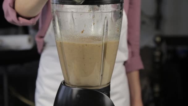 woman cooking at home, banana chocolate shake. mixing ingredients in a blender. healthy food - Metraje, vídeo