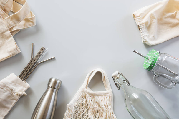 Eco natural metallic straws, cotton bag, glass and metal bottle on grey.Sustainable lifestyle concept. Zero waste, plastic free. Pollution environment. - 写真・画像