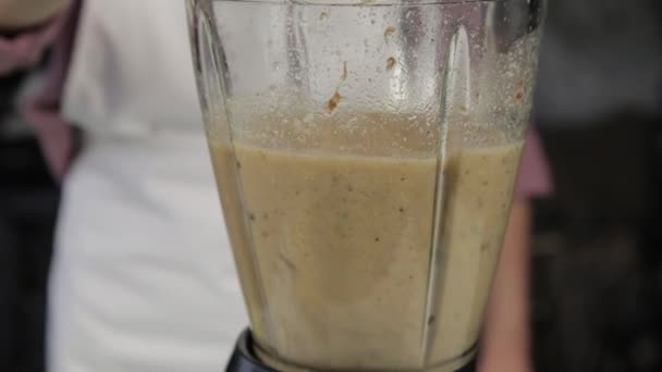 Frau kocht zu Hause, Bananenschokolade Shake. Zutaten in einem Mixer mischen. gesunde Ernährung - Filmmaterial, Video