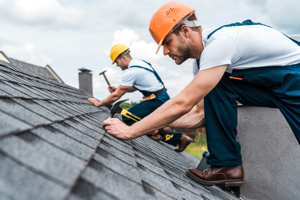 yakışıklı handyman seçici odak iş arkadaşı ile çatı tamir  - Fotoğraf, Görsel