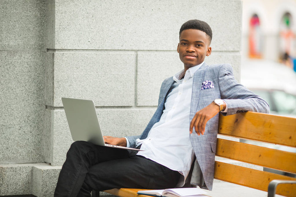 handsome african man in suit with laptop - Фото, зображення