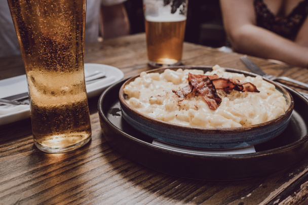 Mac e queijo com bacon em uma mesa de madeira, foco seletivo
. - Foto, Imagem