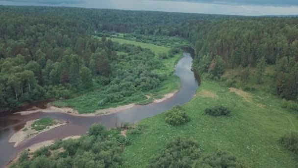 Letecký pohled na krásnou ruskou řeku ležící mezi zelenou loukou a smíšeným lesem proti oblačenému nebi v letním dni. Skladní záběry. Malebný výhled z Ruské přírody - Záběry, video