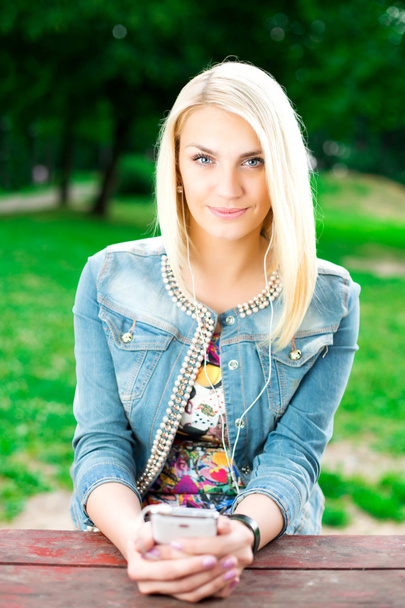 Young blond girl listening music - Foto, afbeelding
