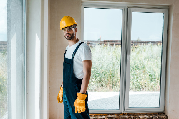 handsome repairman in goggles and yellow gloves  - Photo, Image