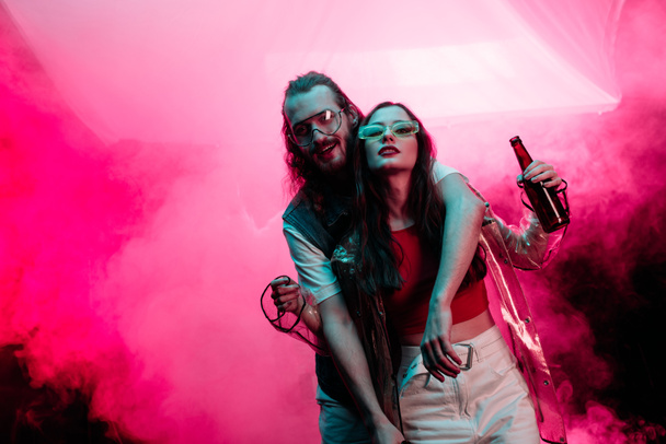 beautiful young woman with beer and handsome man in nightclub during rave  - Photo, Image