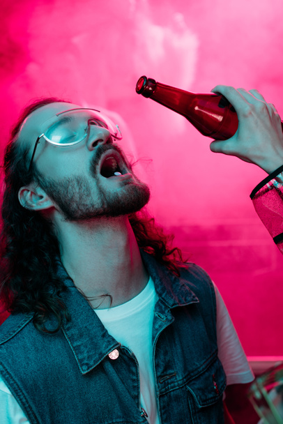 mujer vertiendo alcohol en la boca del hombre en gafas de sol con lsd en la lengua en discoteca
  - Foto, imagen
