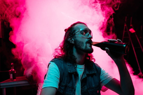 man in sunglasses drinking alcohol during rave in nightclub - Фото, зображення