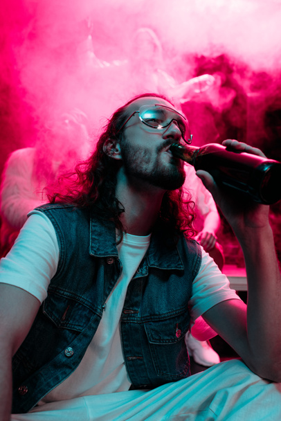 man in sunglasses drinking alcohol during rave in nightclub - Fotoğraf, Görsel