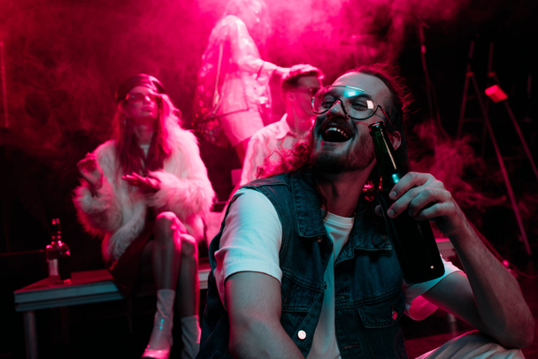 happy man with beer laughing in nightclub during rave - Fotografie, Obrázek