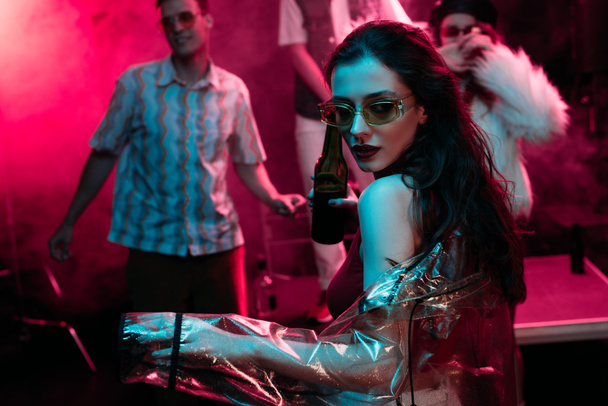 kız bira tutan ve pembe duman ile gece kulübünde dans - Fotoğraf, Görsel