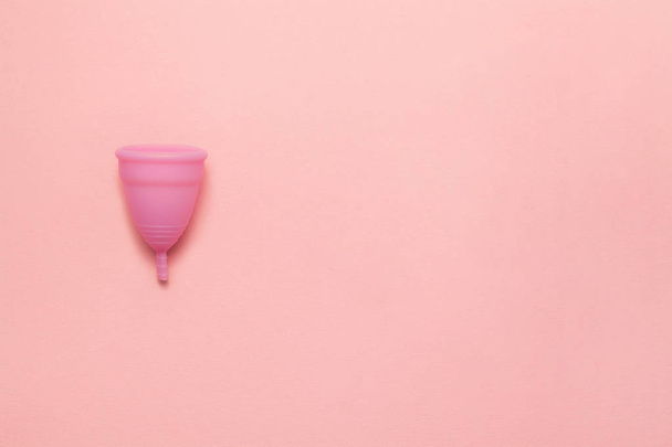 Wielokrotnego użytku silikonowy kubek menstruacyjny na miękkim różowym tle. Nowoczesna kobieta intymna alternatywa ginekologii higieny. Koncepcja ekologicznego zerowania odpadów. Kopiuj miejsce dla tekstu. Płaski lay - Zdjęcie, obraz