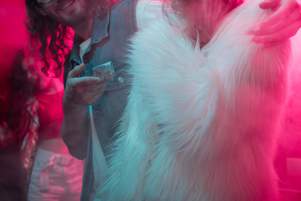 vista recortada de hombre dando hierba en bolsa de plástico con cremallera a chica en discoteca
 - Foto, Imagen
