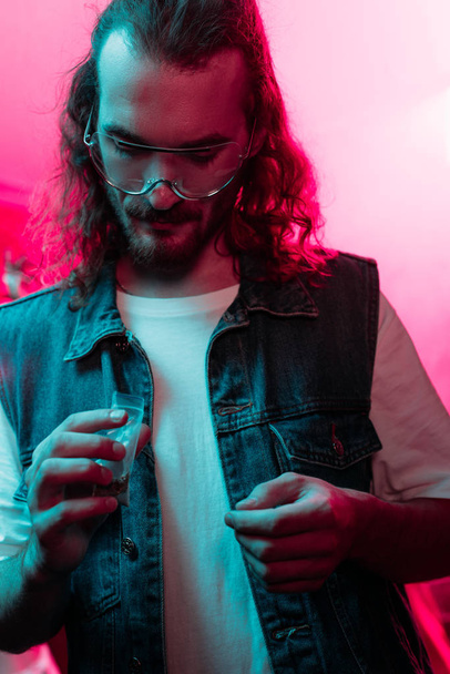 man holding plastic zipper bag with marijuana in nightclub - Photo, Image