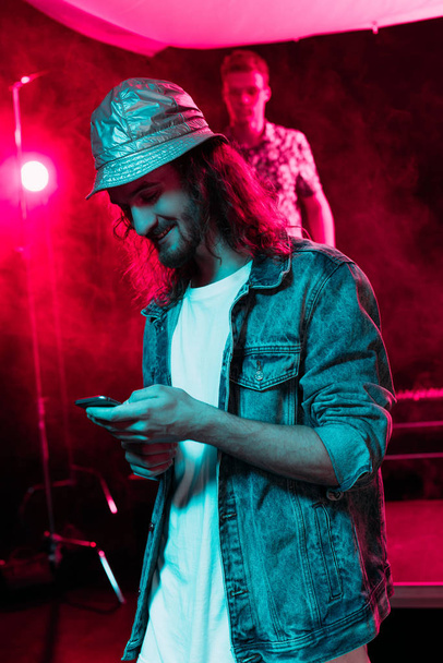 man die smartphone gebruikt tijdens rave party in Nightclub - Foto, afbeelding