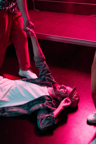 smiling man lying on floor in nightclub with dramatic lighting - Photo, image