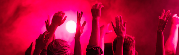 plan panoramique de la vue de dos des personnes avec les mains levées pendant la fête de rave dans la boîte de nuit
 - Photo, image